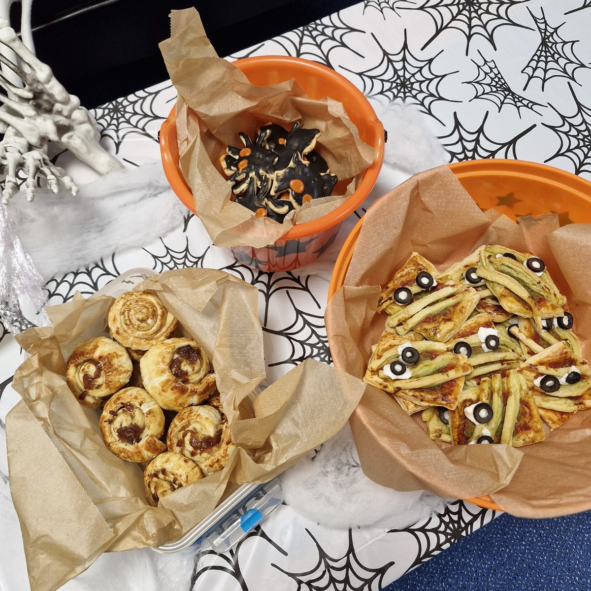 Cheese and chutney pinwheels, pesto mummy pastries and chocolate spider biscuits in orange Halloween buckets